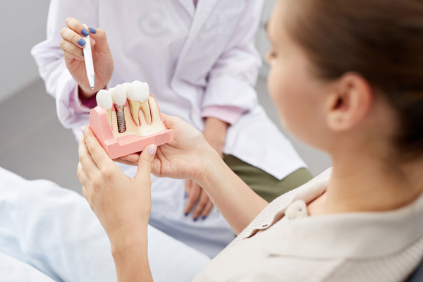 Image of a patient holding a dental implant model next to a dental professional, at Capital Dental Center in Washington, DC.